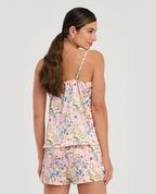 Mujer de espalda con pijama de satín rosada y flores, blusa de tiras ajustables y short cómodo de St. Even.