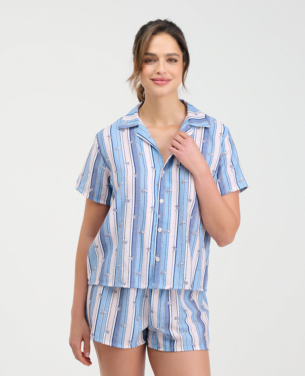 Mujer con pijama de short y camisa manga corta con botones en tejido plano a rayas azules y blancas de St. Even.