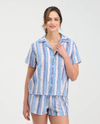 Mujer con pijama de short y camisa manga corta con botones en tejido plano a rayas azules y blancas de St. Even.