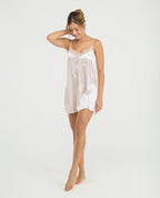 Modelo luciendo pijama batola de satín color perla con escote en V y encaje, ideal para ropa de dormir elegante.