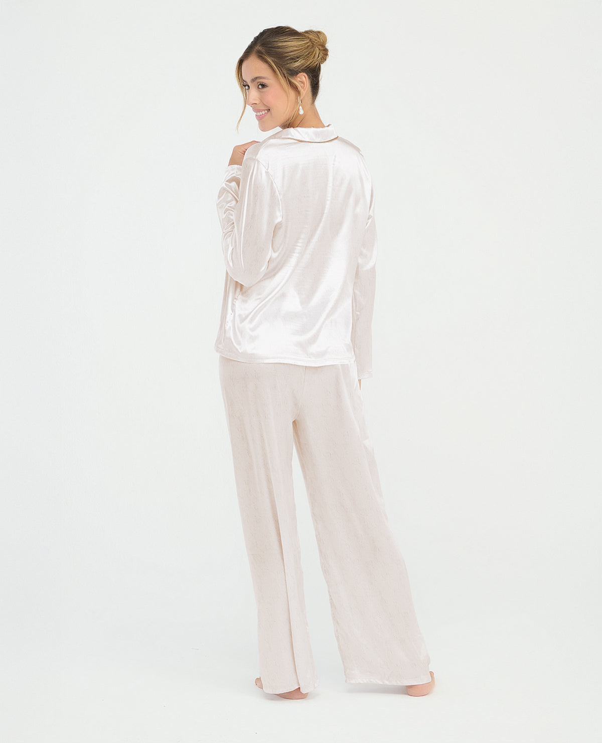 Pijama para mujer en satín marfil con camisa de manga larga y pantalón largo de ajuste relajado.