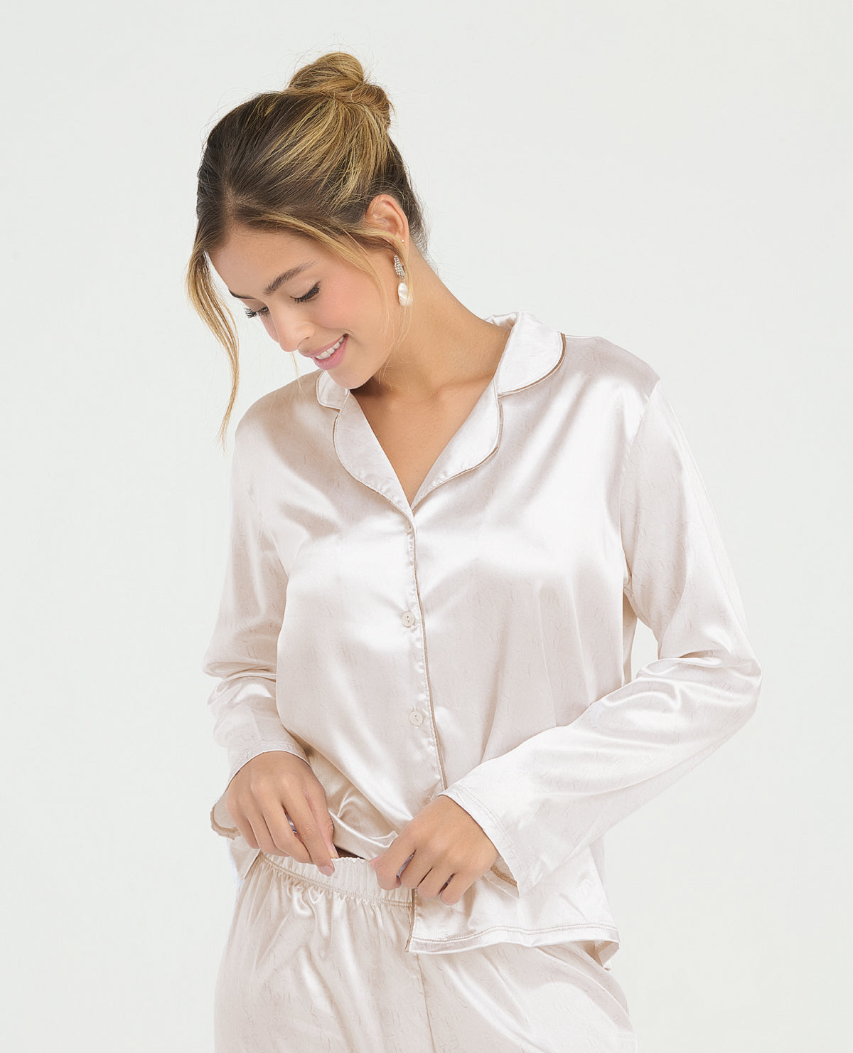 Pijama de mujer en satín color champaña con camisa de manga larga, cuello clásico y pantalón de cintura elástica.