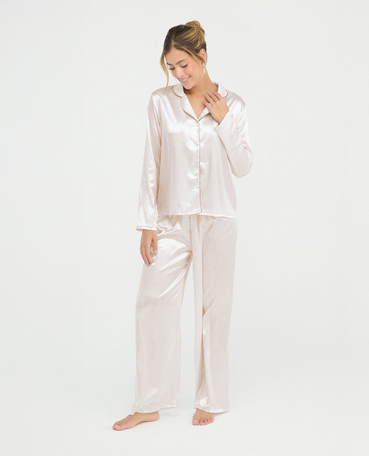 Pijama para mujer en satín marfil con camisa de manga larga, cuello clásico y pantalón largo de ajuste relajado.