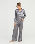 Pijama de satín gris para mujer con camisa de manga larga, cuello clásico y pantalón relajado de tiro alto.