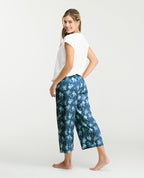 Pijama para mujer con pantalón capri satinado azul estampado y camiseta blanca de cuello redondo.