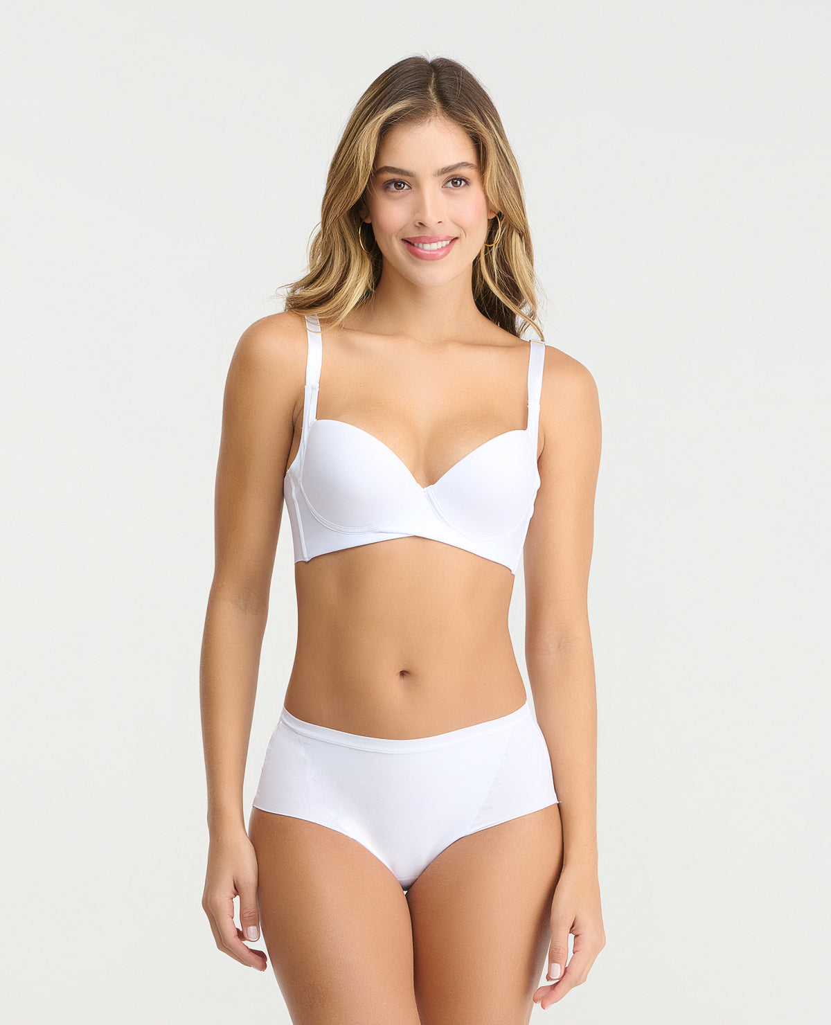Modelo en panty cachetero blanco tiro medio con control de abdomen y corte limpio sin costuras frontales.