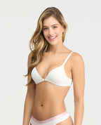 Brasier blanco con realce natural, escote profundo y broche frontal dorado en modelo con fondo claro.