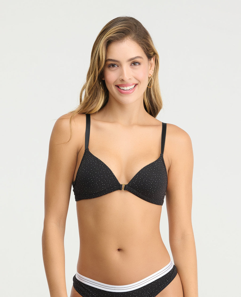 Brasier negro con estampado de puntos blancos, escote profundo y broche frontal metálico para realce natural.