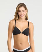 Brasier negro con estampado de puntos blancos, escote profundo y broche frontal metálico para realce natural.