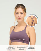 Top deportivo morado de silueta ajustada con copas fijas, cargaderas dobles y detalle de espalda cruzada.