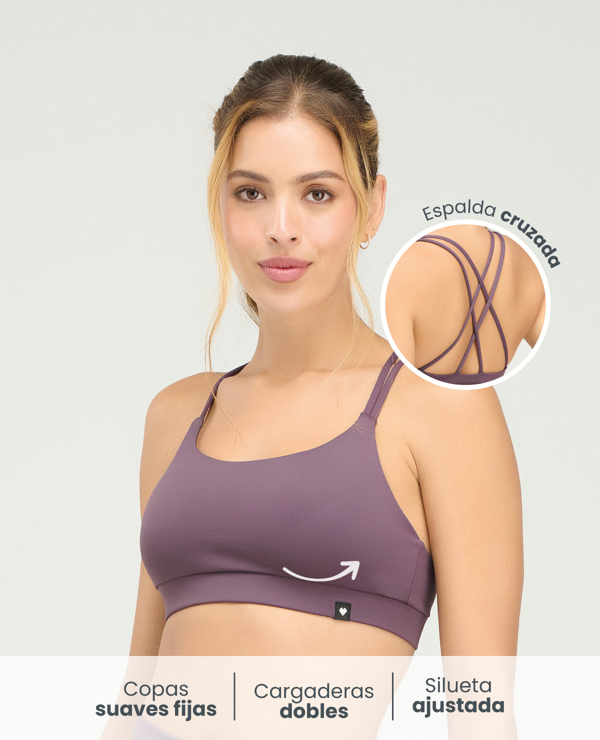 Top deportivo morado de silueta ajustada con copas fijas, cargaderas dobles y detalle de espalda cruzada.
