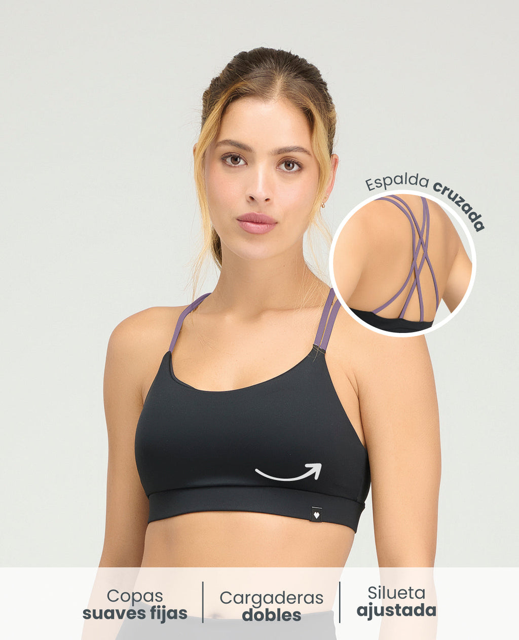 Top deportivo negro con copas suaves fijas, silueta ajustada y diseño de cargaderas dobles moradas con espalda cruzada.