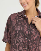 Camisa de botones manga corta para mujer con estampado animal print, silueta amplia y cuello clásico.