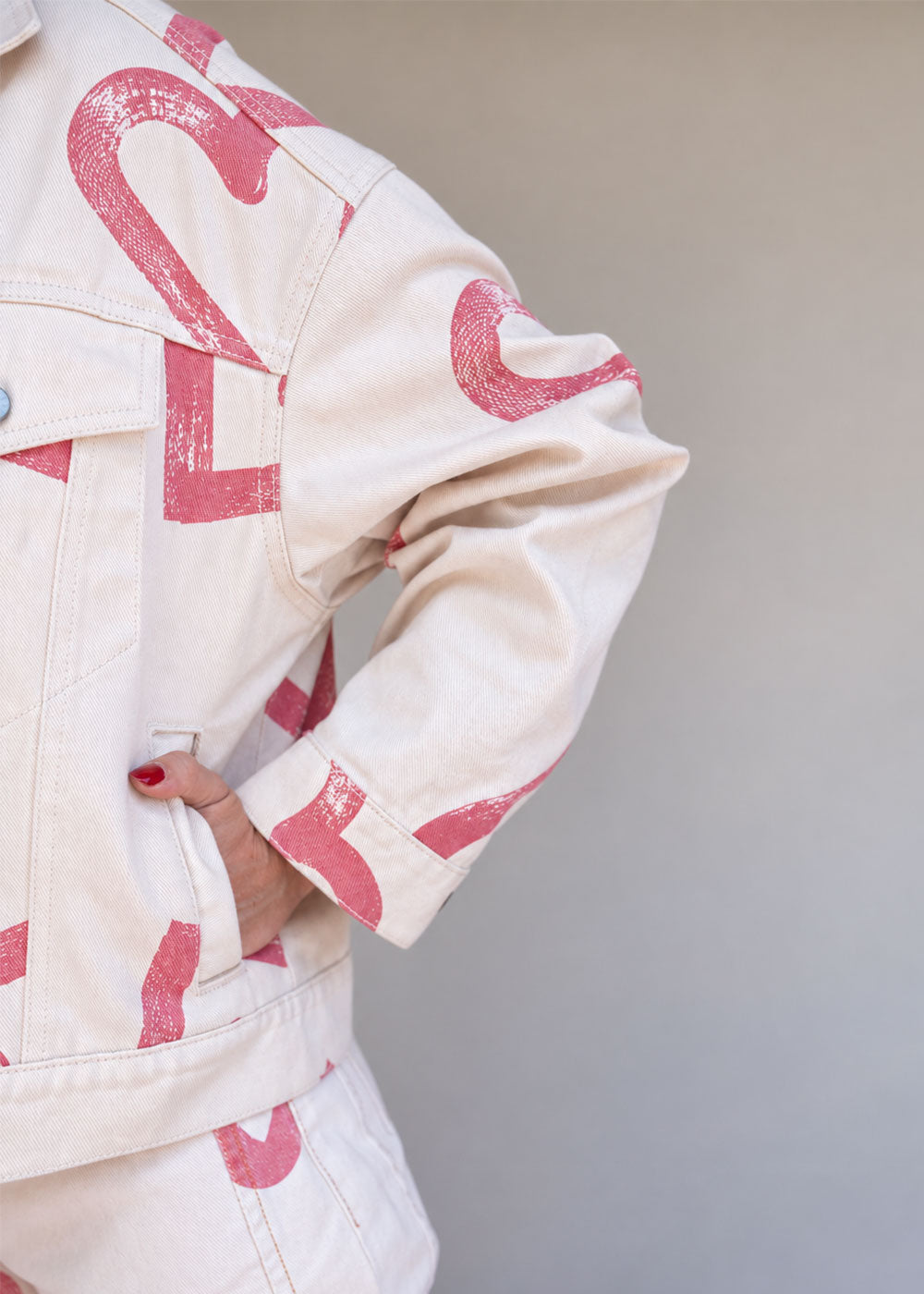Ivory cotton drill denim jacket with all-over red heart print, front pockets, and barrel sleeves, view 6