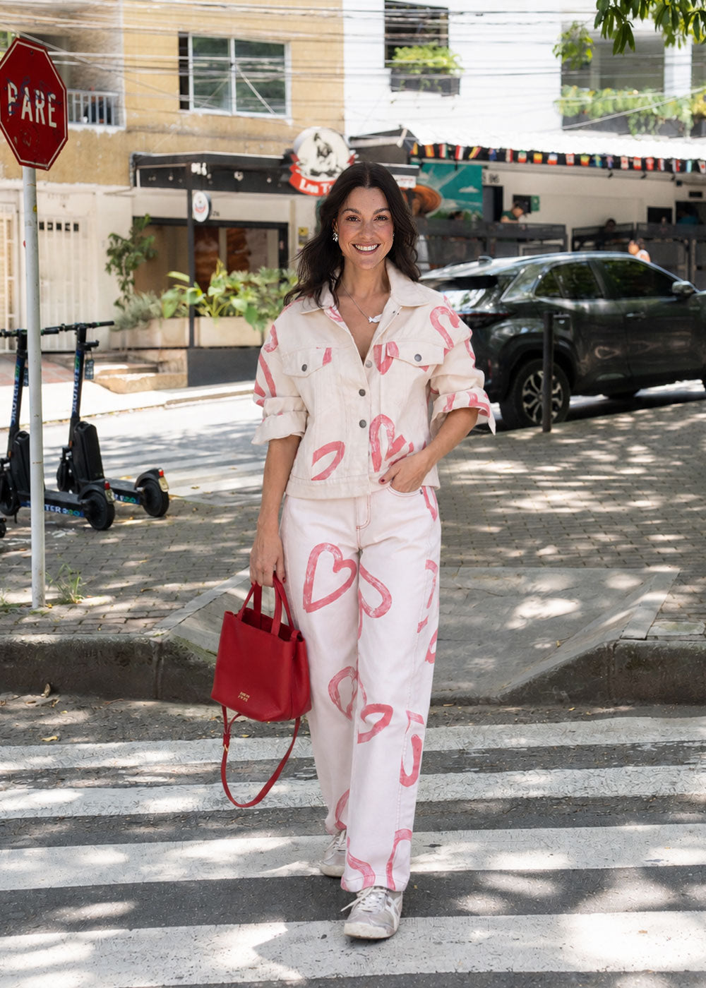 Ivory cotton drill jean with all-over red heart print, wide leg, side cuts, and knee darts, view 3