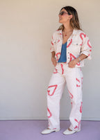 Ivory cotton drill jean with all-over red heart print, wide leg, side cuts, and knee darts, view 4