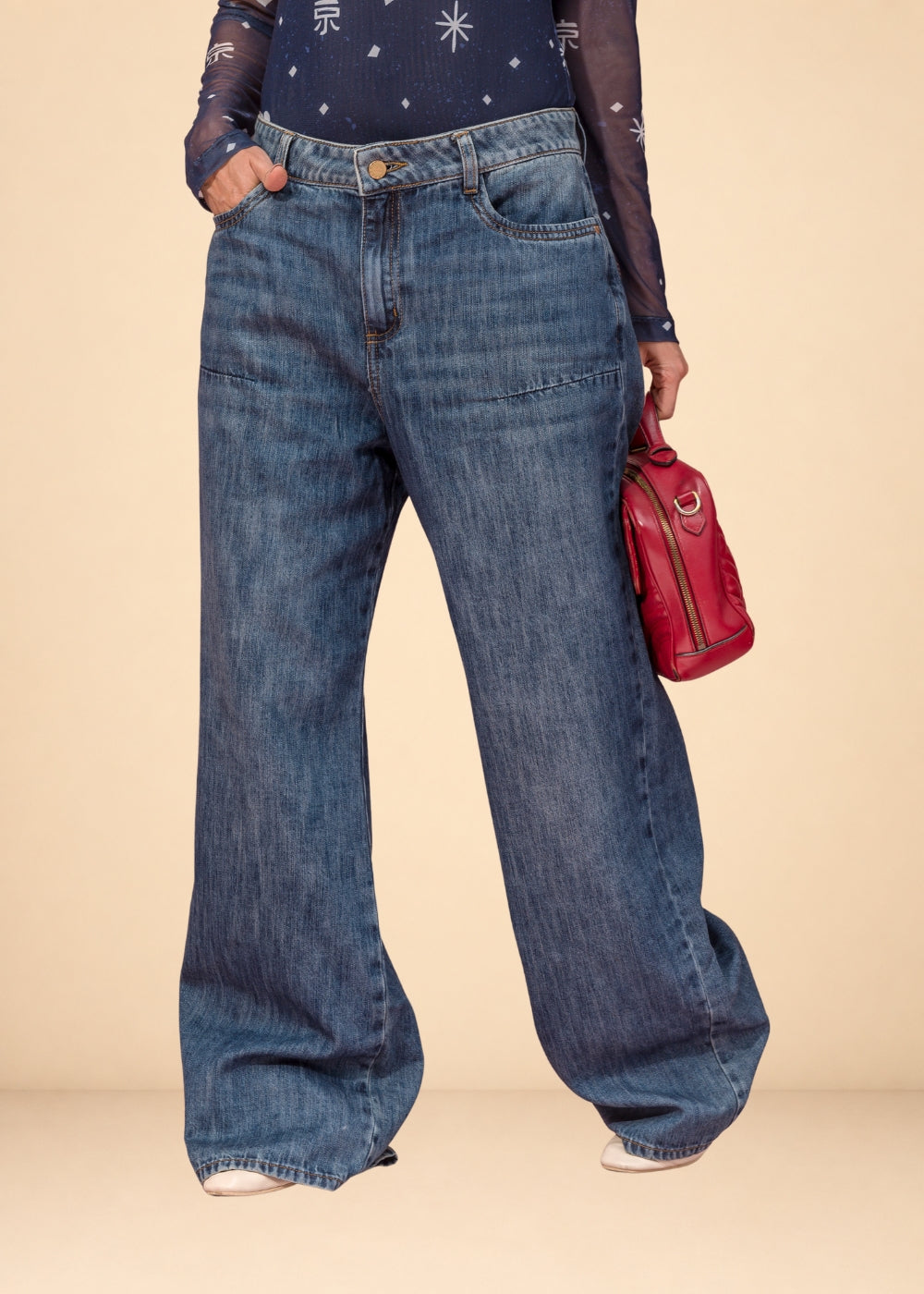 Rigid indigo denim jean with belted waistband, straight leg, and functional pockets