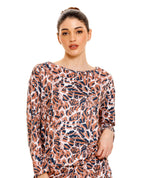Buzo de pijama para mujer con estampado animal print, manga larga, cuello redondo y silueta suelta sobre fondo blanco.