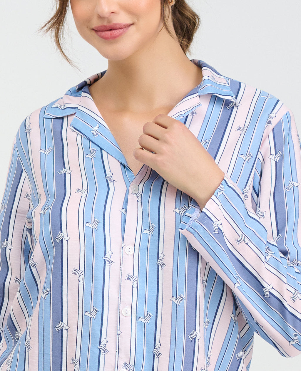 Pijama para mujer con camisa manga larga de rayas azules y rosadas con estampado de cebras y botones frontales.