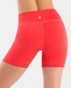 Short deportivo tipo ciclista color coral de talle alto con detalle de gel lateral y silueta ajustada para mujer.