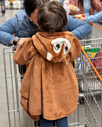 Ruana Ardilla café de Dosmicos: vista de espalda con los detalles de la capota, usada por un niño durante una salida al supermercado.