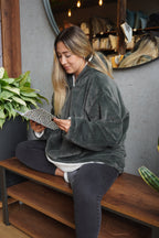 Cozy oversized Saco Teddy Oliva in soft, olive-green fur, featuring a hood and pockets, ideal for any cozy space.