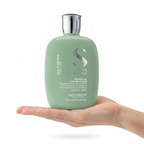 Semi Di Lino Scalp Renew sostenido por una mano