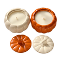 Cream and orange Pumpkin Charm candles in pumpkin-shaped jars, shown with matching lids beside them.