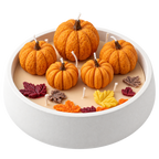 Vela artesanal tipo fuente con decoración otoñal de calabazas y hojas, fondo transparente.