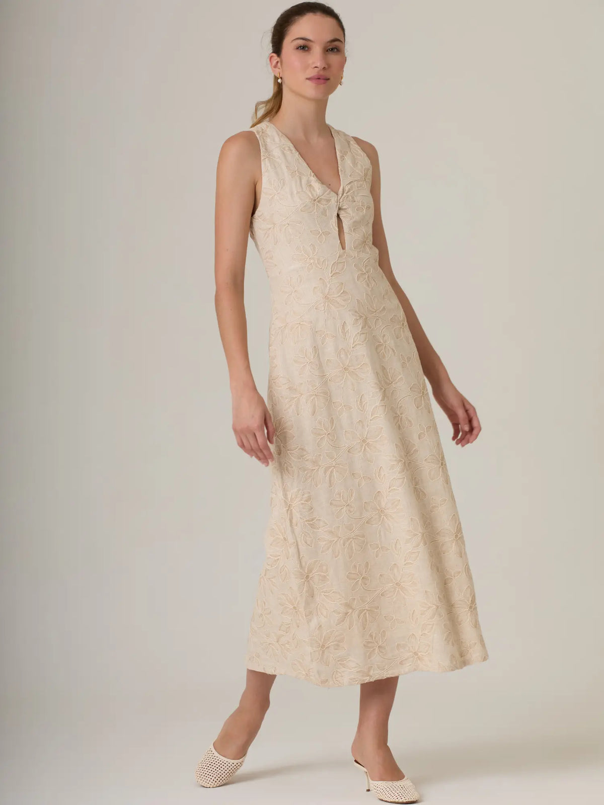 Vestido beige bordado con textura de flores y silueta sofisticada perfecta para eventos especiales.